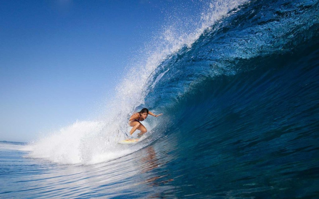 Woman surfing in crest of wave